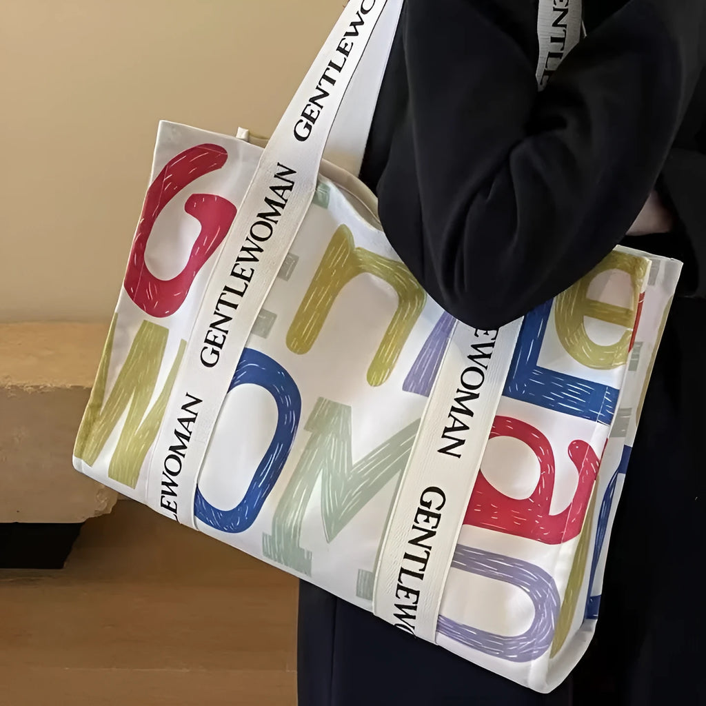 Canvas women's travel tote bag with printed design options including black letters, coloured letters, and pattern styles