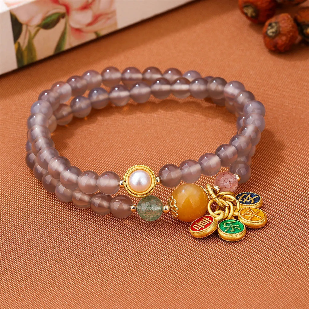 Close-up of a grey agate two-circle women's bracelet with a stainless steel clasp on a wrist.