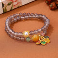 Close-up of a grey agate two-circle women's bracelet with a stainless steel clasp on a wrist.