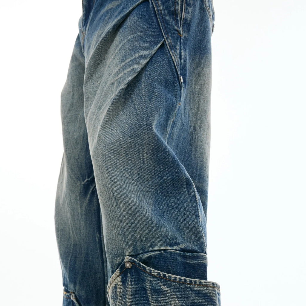 Man wearing verdant blue loose-fit retro jeans with a curved knife washed pattern on the legs.