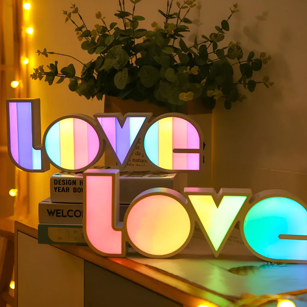 Rainbow style plastic LOVE LED decorative light on a surface.