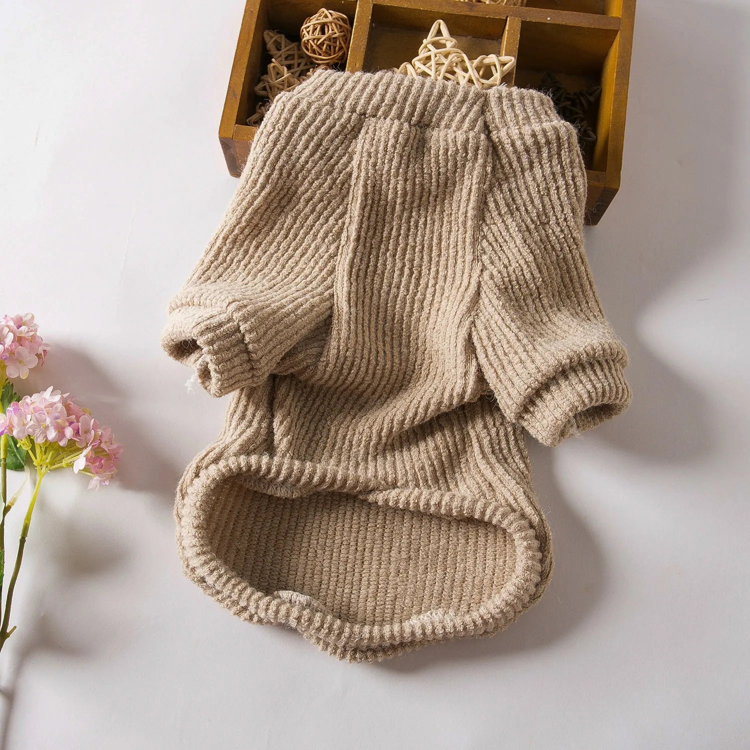 Brown cloth dog pullover sweater on a small white dog, showing casual style.