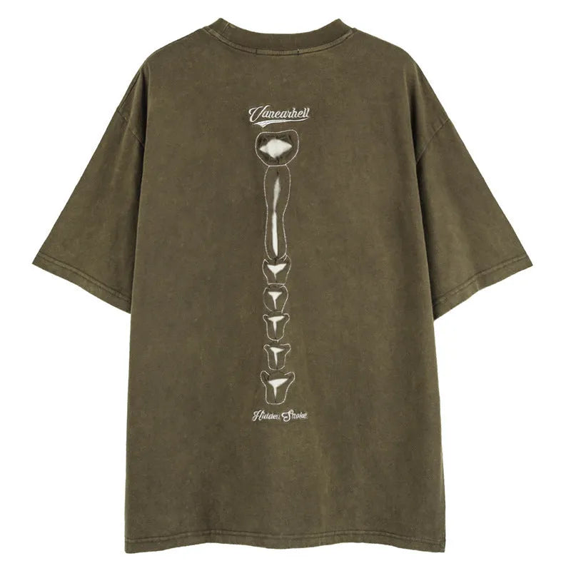 Man's loose brown t-shirt with a large black skull and letter graphic print on the front, featuring drop-shoulder sleeves.