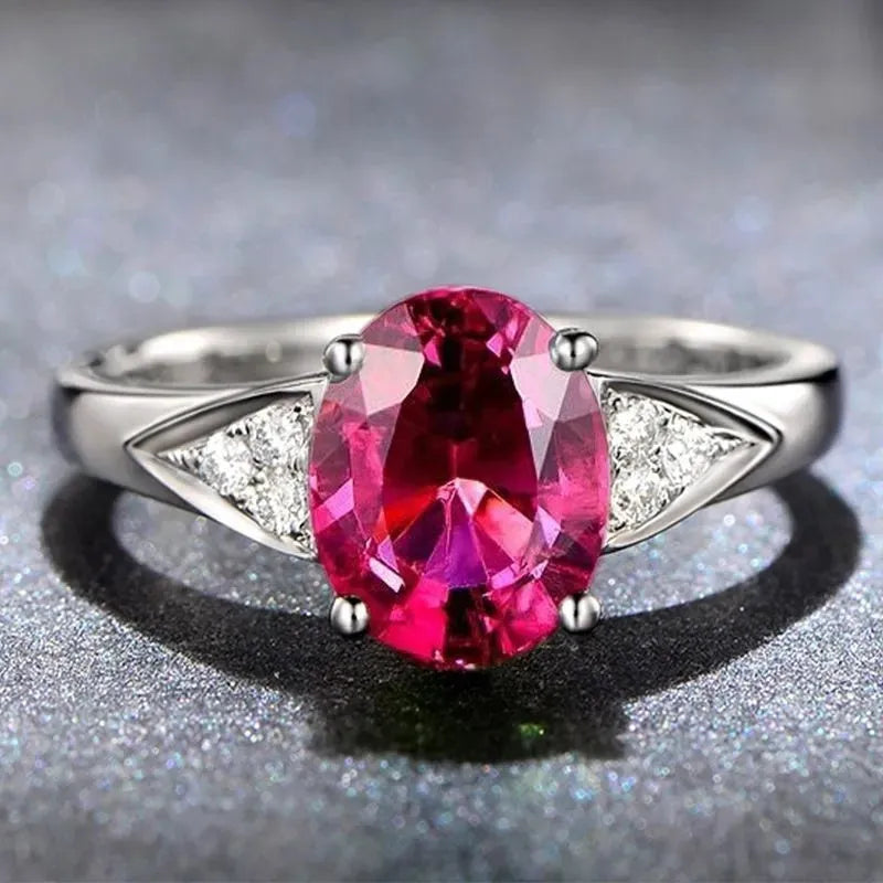 A women's sterling silver ring with a geometric pattern of inlaid red and blue natural zircon stones on a comfort-fit band.