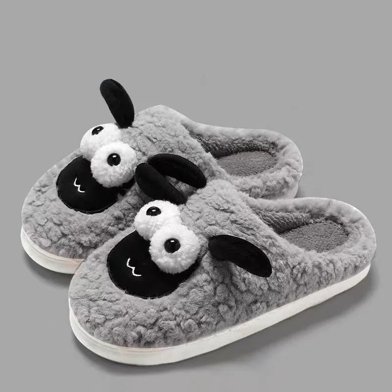 Brown suede slip-on slippers with a PVC sole on a wooden floor.