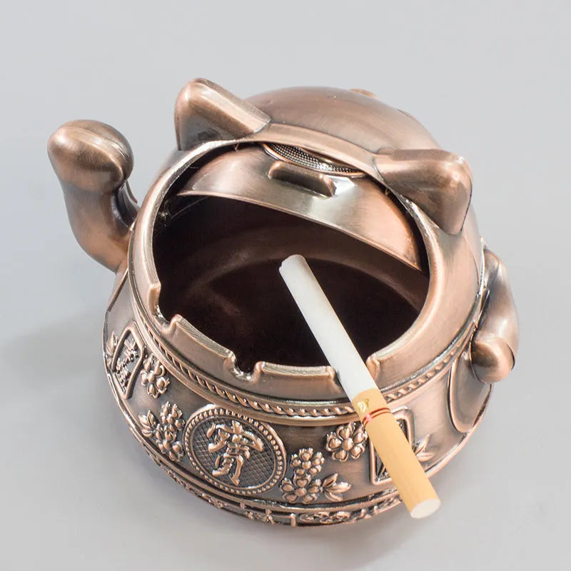 Zinc alloy lucky cat ashtray with cover in gold black colour on a wooden table