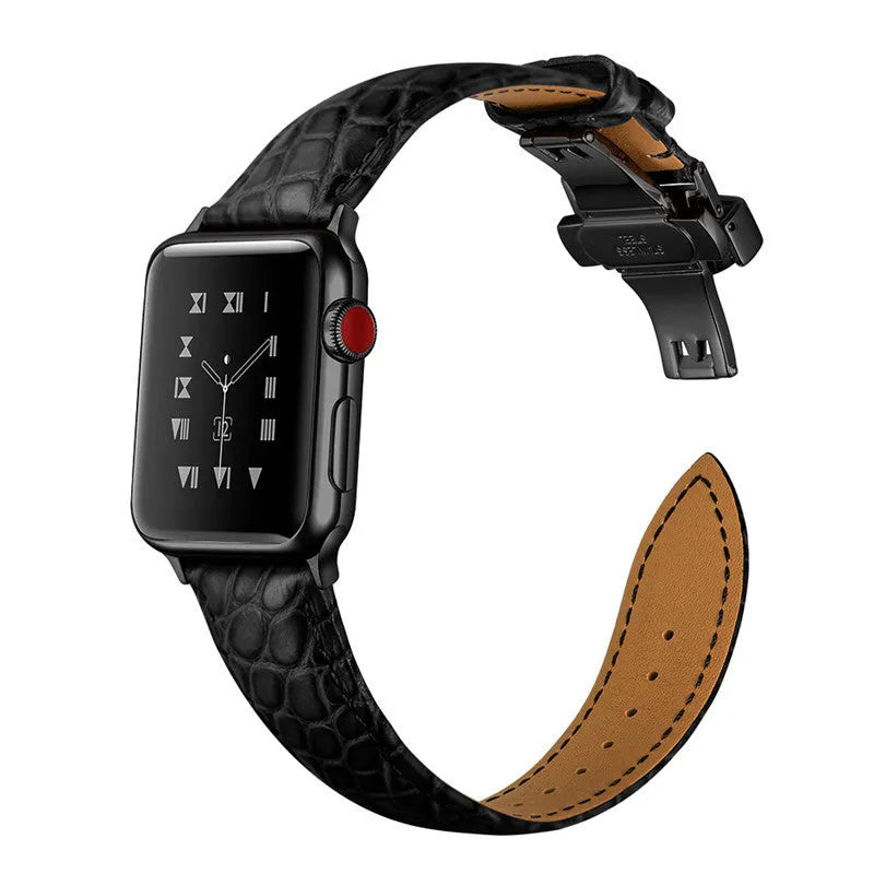 Genuine crocodile skin watch strap in brown with rose gold buckle, 42-44mm width, on a wooden surface