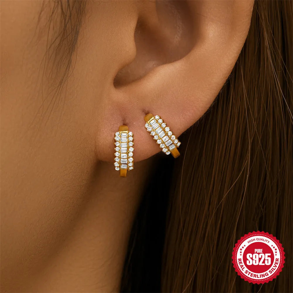 A pair of small round geometric stud earrings in sterling silver with a gold electroplated finish.