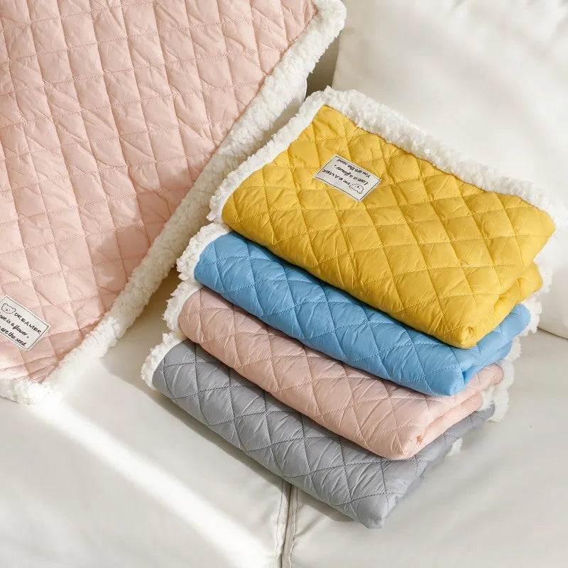 Blue quilted terry cloth cat blanket shown in a pet bed.