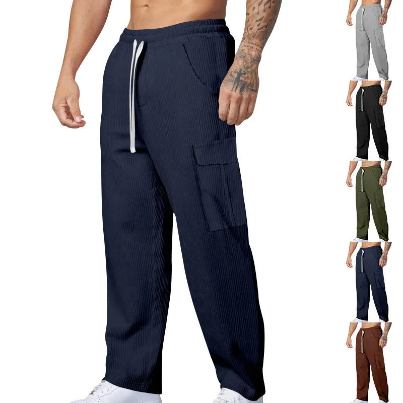 Man wearing navy blue loose-fit corduroy cargo trousers with a drawstring waist.