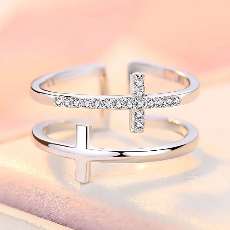 Women's adjustable copper ring with double cross design and white zircon stone in sterling silver inlay.