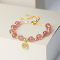 Women's Strawberry Quartz crystal bracelet with geometric design and fu character charm on wrist