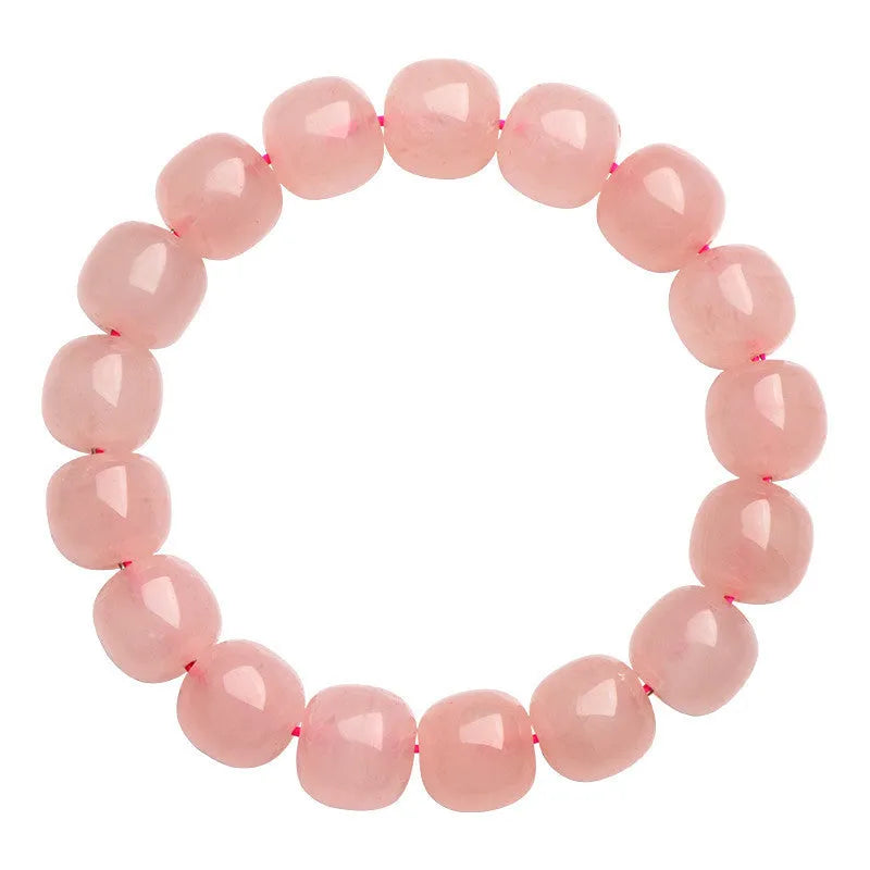 Natural pink crystal barrel bead bracelet with geometric design on a wrist.