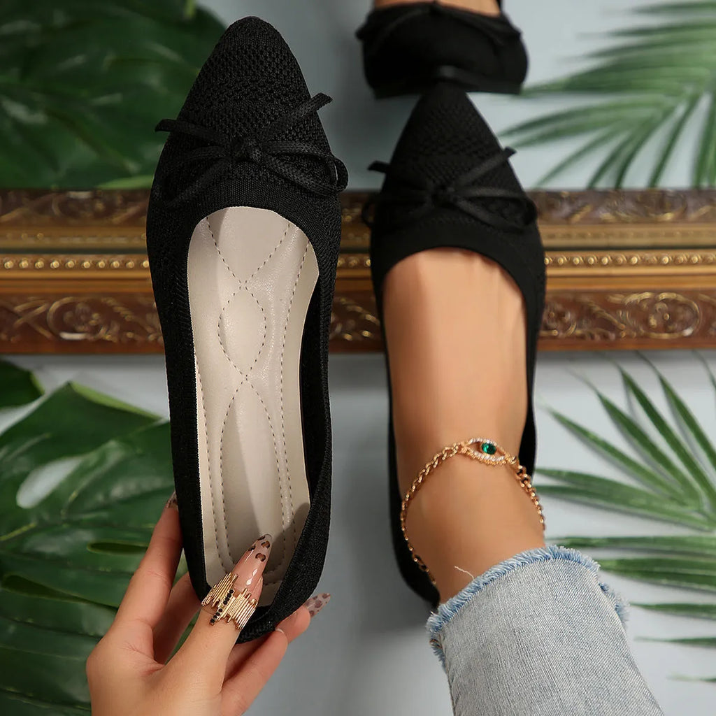 Women's blue knitted flat loafers with a pointed toe and a decorative bow on the front