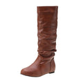 Women's flat heel knee-high slip-on boot in black with round toe and rubber sole