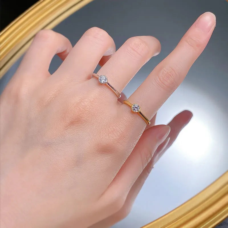 Minimalist crown-shaped silver ring in gold or platinum finish, shown in a simple setting.