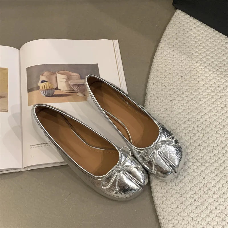 Women's split-toe flat pumps in beige with a round toe and flat rubber sole.