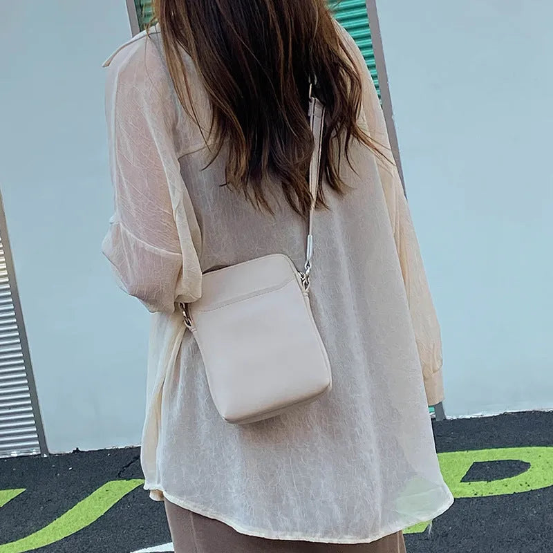 Solid colour PU leather crossbody phone bag for women in beige, showing front view.