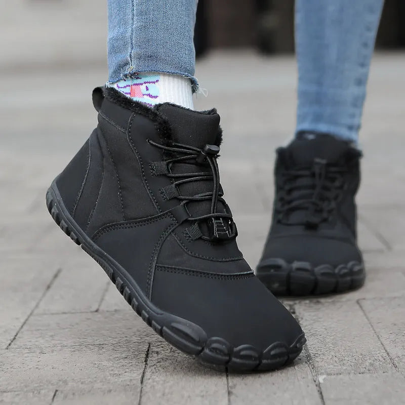 Unisex round-toe lace-up snow boots in black on a wet surface, showcasing the rubber sole tread.