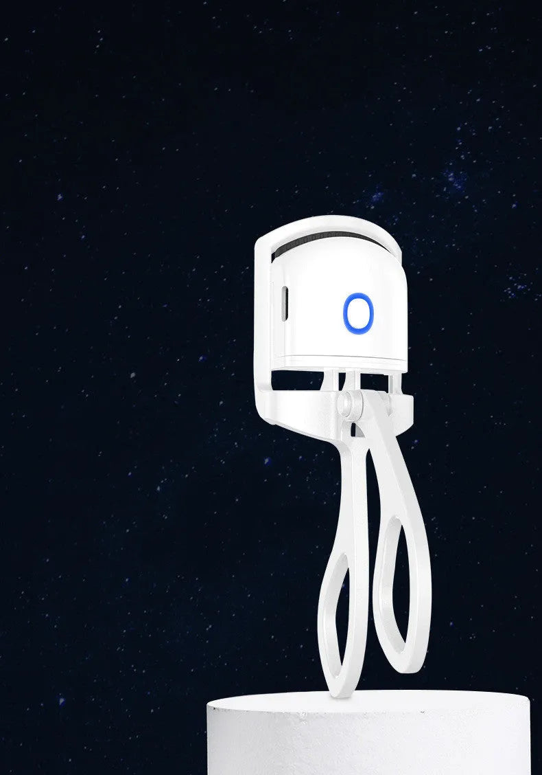 White USB rechargeable heated eyelash curler with a curved design and a small LED light.