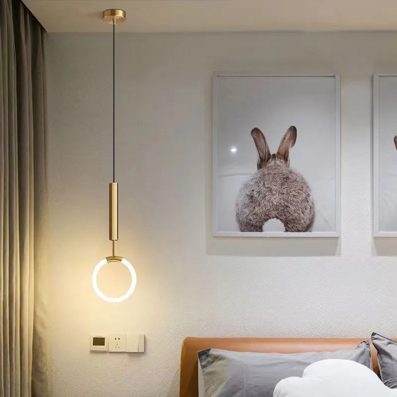 Compact Nordic minimalist U-shaped white pendant light with fabric cord, shown mounted beside a bed.