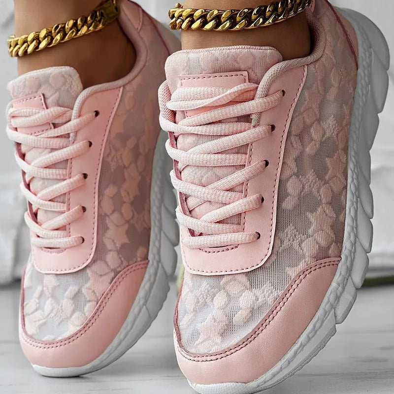Women's white canvas running shoes with a flat heel and round toe on a plain background.