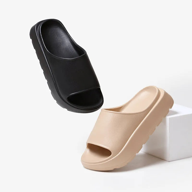 Women's beige fish mouth slippers with a thick EVA sole on a bathroom tile floor.