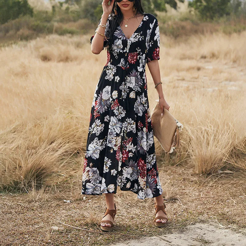 Yellow floral print dress on a hanger showing V-neck, short sleeves, elastic high waist, and full mid-length skirt.