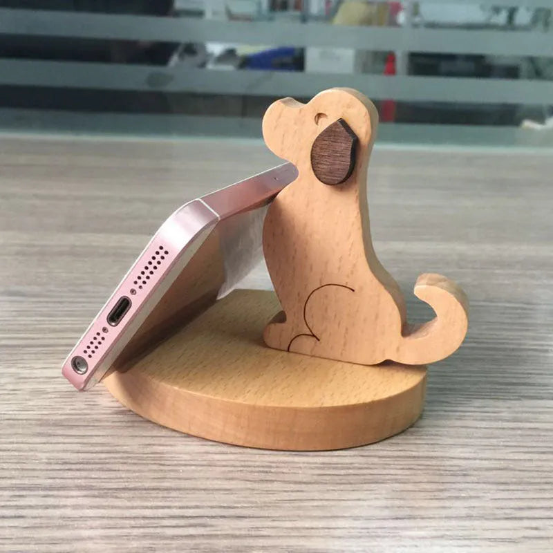 Sculpted beech wood lazy bracket phone holder with custom engraved text on a wooden desk.