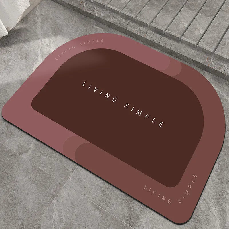 Oval grey polyester door mat with textured rubber non-slip backing on a wooden floor.