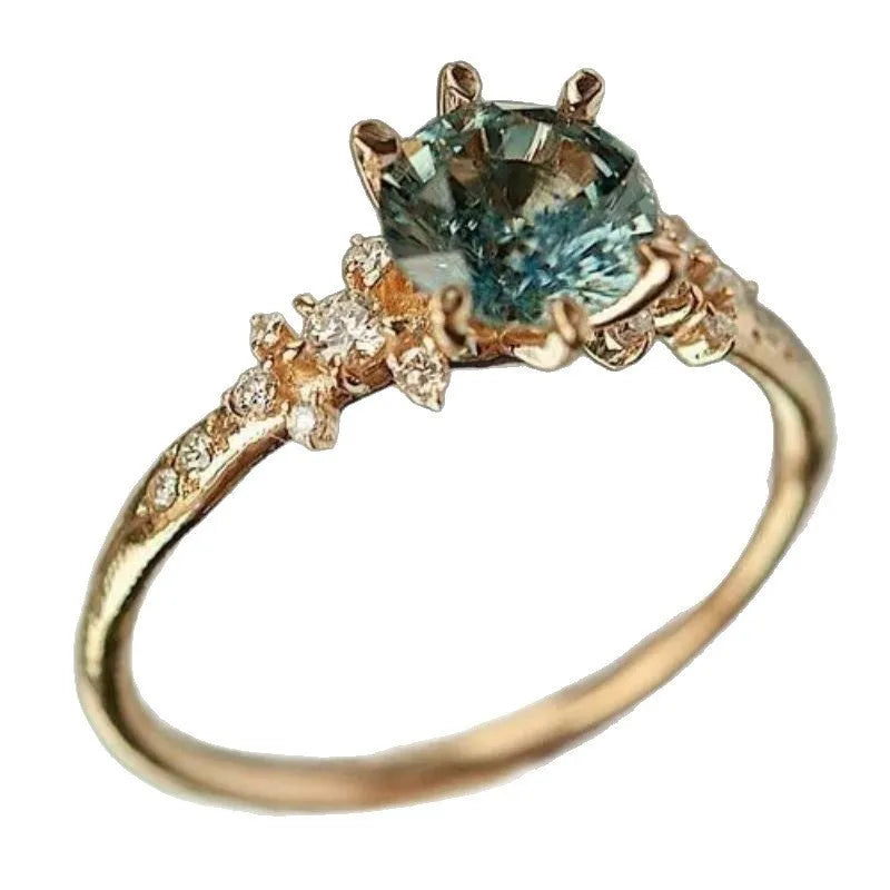 Gold coloured geometric ring with claw-set zircon stones and a chamfered square design.