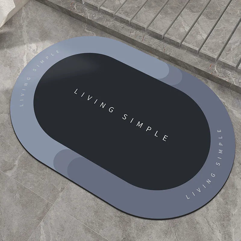 Oval grey polyester door mat with textured rubber non-slip backing on a wooden floor.
