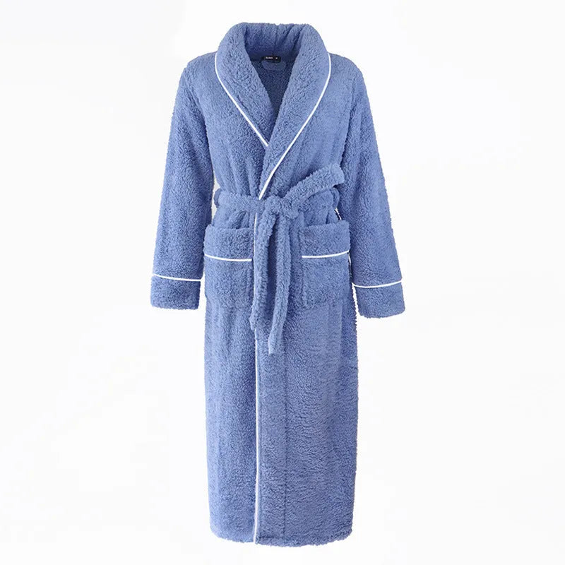 A man and woman wearing matching thick navy blue flannel bathrobes in a cosy winter home setting.