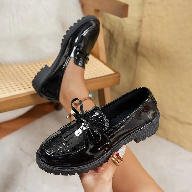 Women's black loafers with a decorative bow detail on the upper.