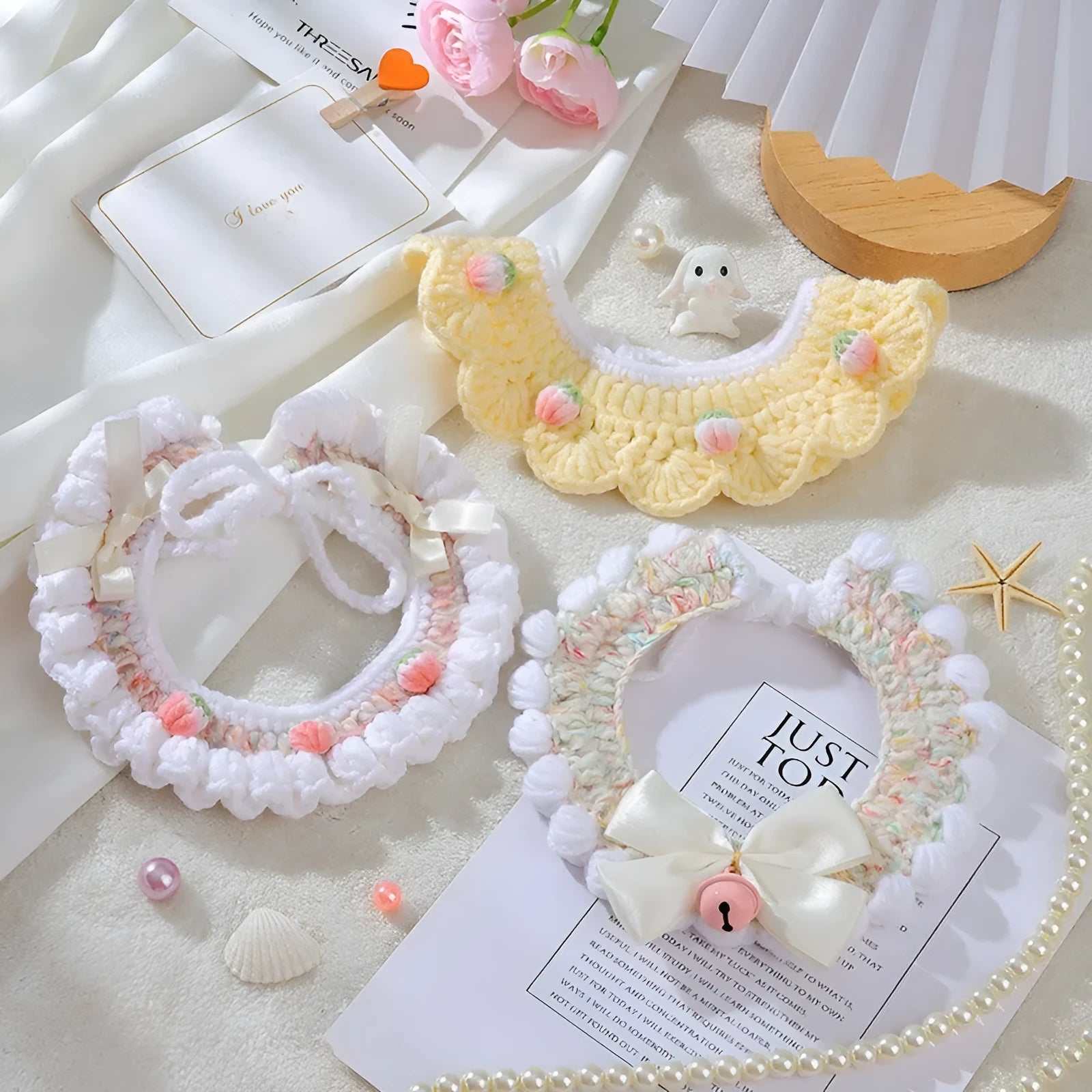Handmade woven wool cat collar with embroidered cartoon British Shorthair kitten in pink, white, and yellow colours.