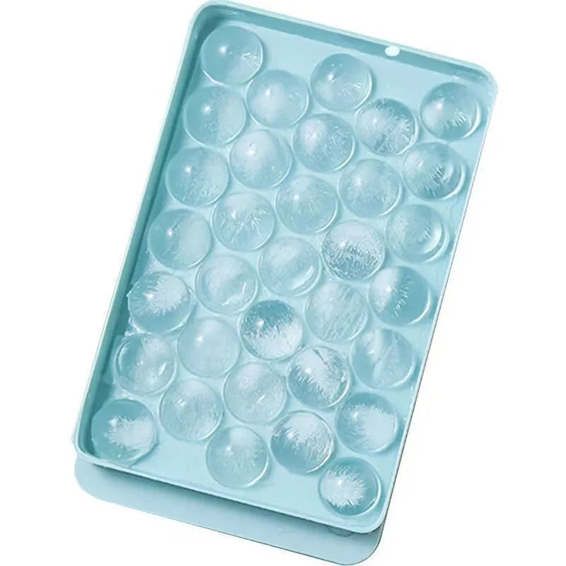 Blue silicone ice tray with lid producing 33 large round ice spheres on a kitchen counter