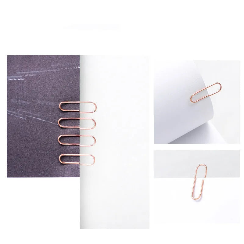 100 rose gold coloured heart-shaped metal paper clips in a box.