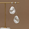 Asymmetric floral earrings with zircon stones in gold or silver finish.