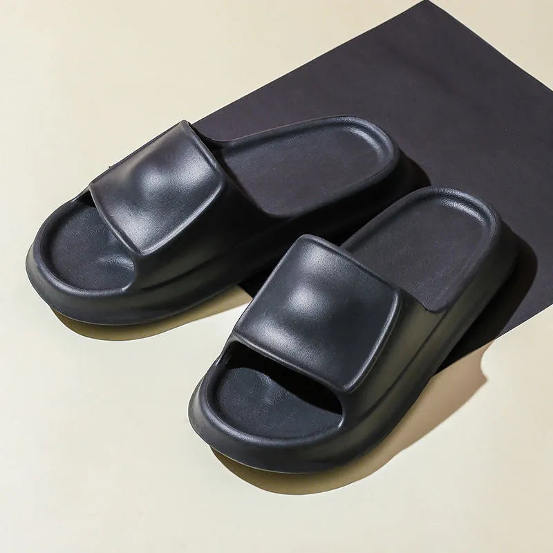 Pair of white EVA flip-flop slippers with a thick, textured sole on a tiled floor.