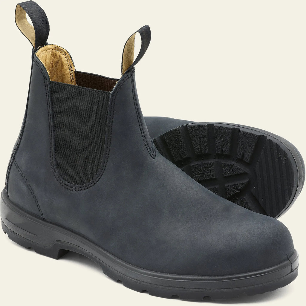 A pair of vintage-style brown Chelsea boots with a round toe and low heel on a wooden floor.