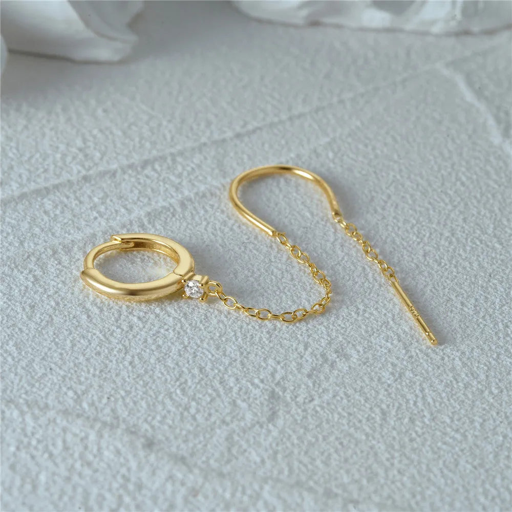 Close-up of a geometric S925 sterling silver clip-on earring featuring a diamond flower and a delicate gold-plated chain tassel.