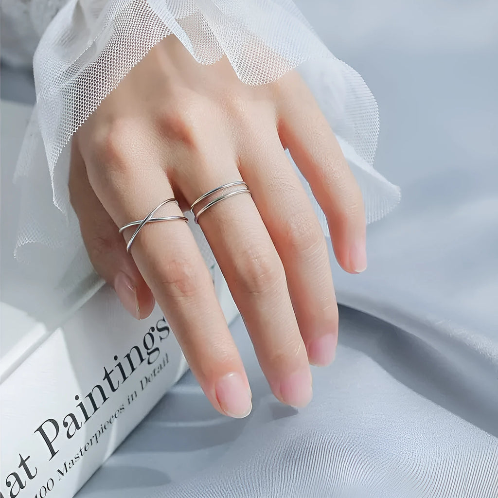 Silver plated geometric cross ring with an adjustable opening on a copper base.