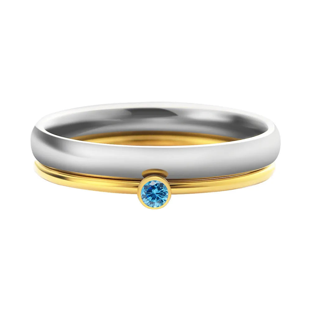 Geometric titanium steel ring with engraved detail and December birthstone colour combination on a finger.
