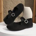 A pair of black men's canvas fisherman flat shoes with a rubber sole on a white background.