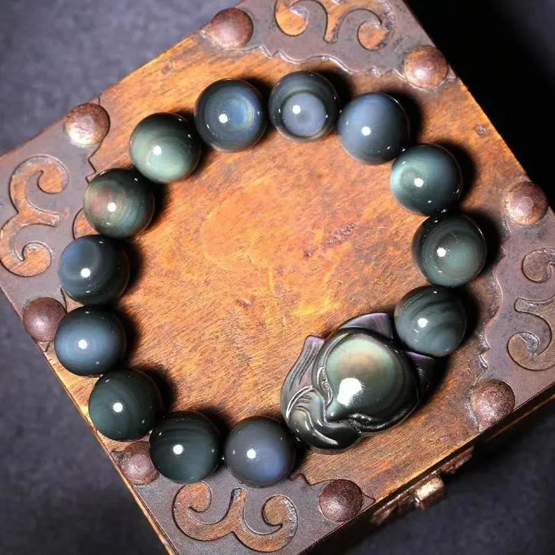 Obsidian fox carved bracelet in cartoon animal style showing detailed carving on black stone surface