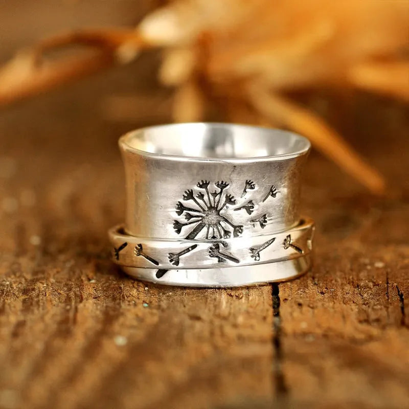 Silver-coloured rotatable flower fashion ring on a finger, showing the floral detail.
