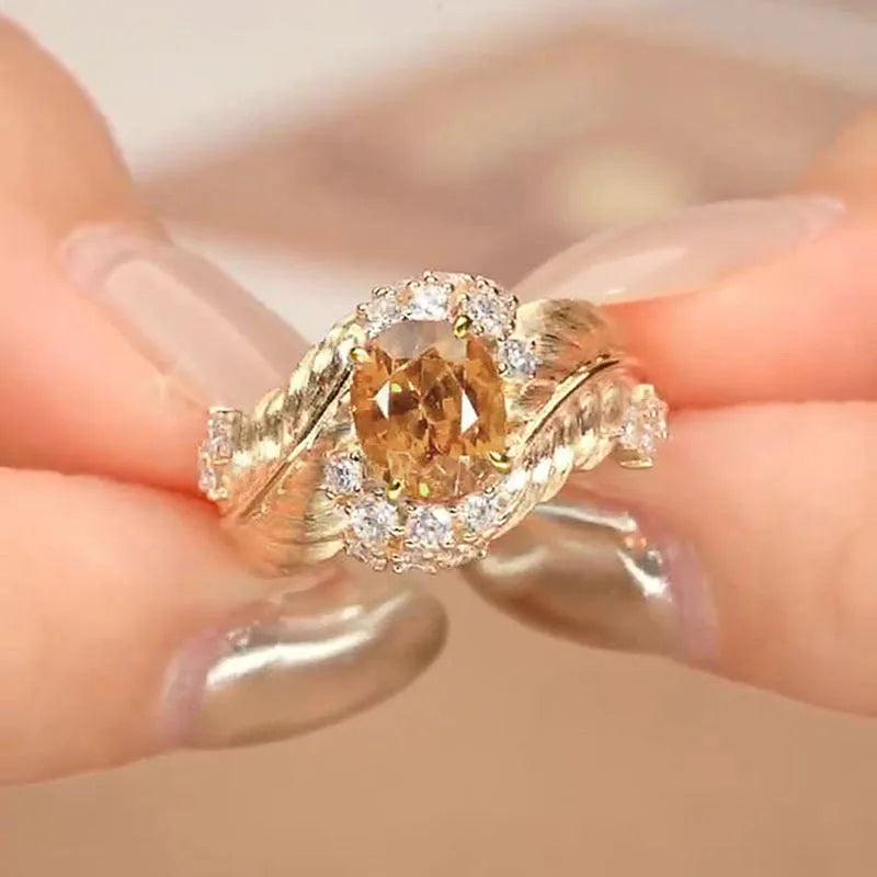 Gold-colour copper women's ring with embossed feather design and yellow zircon stone.