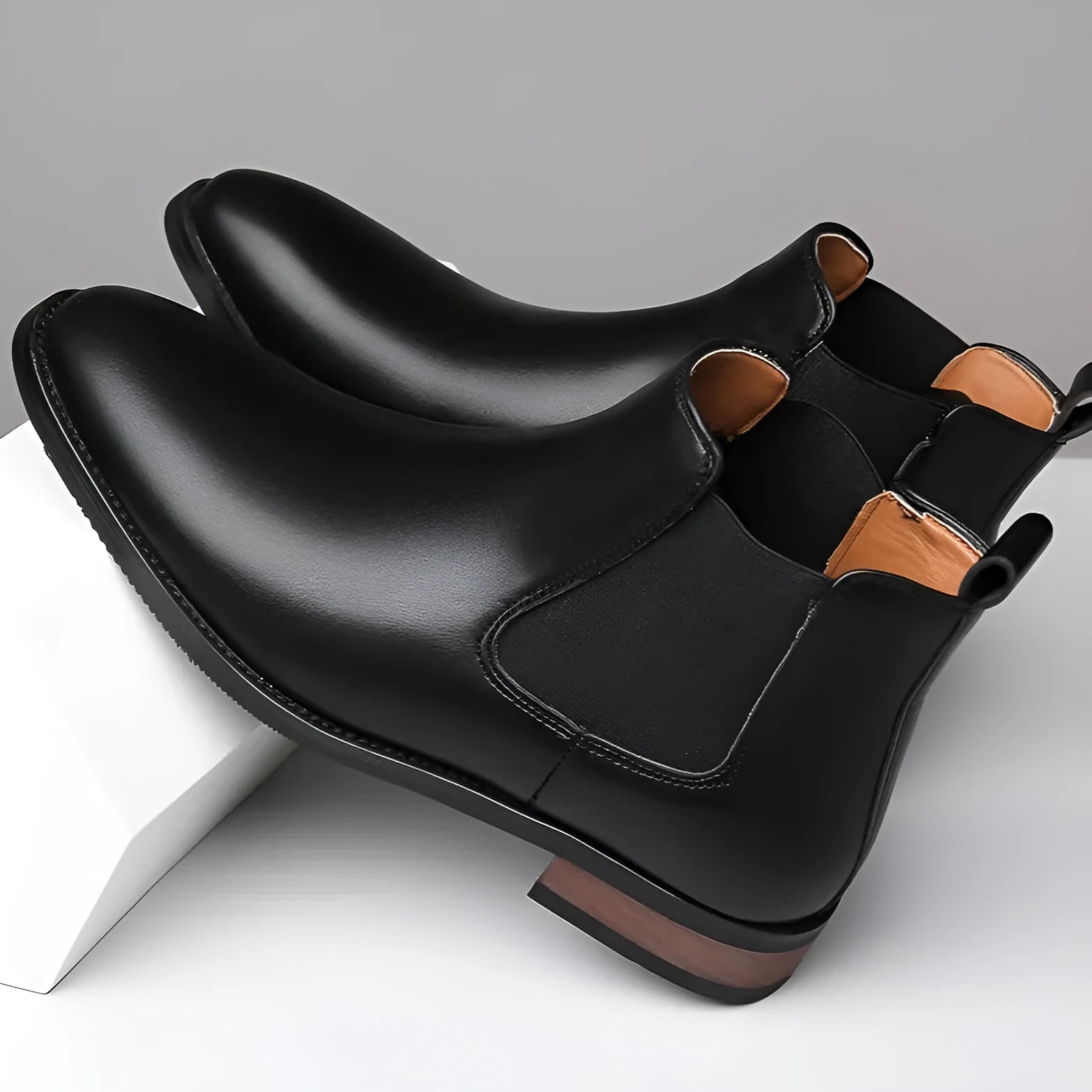 Men's black Chelsea boots with pointed toe design, sewing thread details and rubber sole