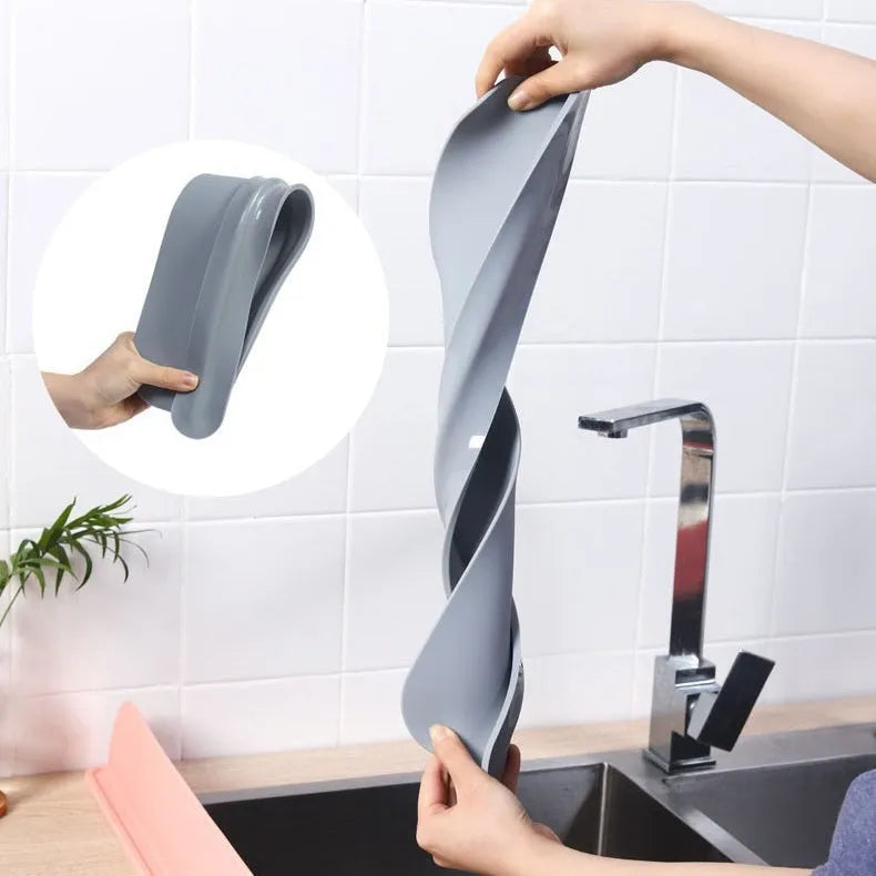 Grey silicone kitchen sink splash guard plate measuring 52mm by 85mm