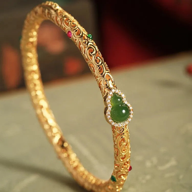 Gold-toned open design gourd charm bracelet with a dark adjustable silk cord for women.